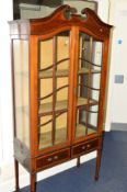 AN EDWARDIAN MAHOGANY ASTRAGAL GLAZED TWO DOOR DISPLAY CABINET above two drawers on square