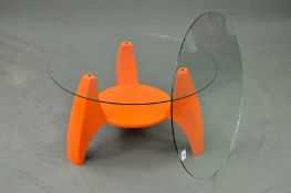 A 1960'S CIRCULAR GLASS TOPPED ROCKET COFFEE TABLE, on an orange fibreglass base, with the choice of