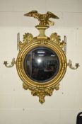 A VICTORIAN GILTWOOD CONVEX MIRROR, the carved eagle surmount with outstretched wings above