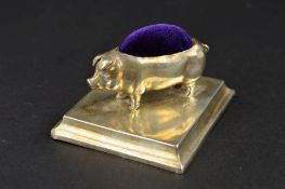 AN EDWARDIAN SILVER PIG PIN CUSHION, on a square base, makers Levi & Salamon, Birmingham 1904,