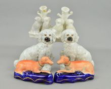 A PAIR OF VICTORIAN STAFFORDSHIRE POTTERY FIGURES OF SEATED DOGS, modelled with fences behind, on