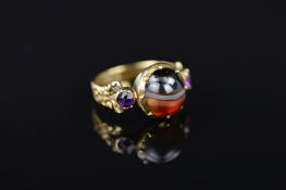 A LATE GEORGIAN GOLD MEMORIAL RING, designed as a central circular banded agate cabochon flanked