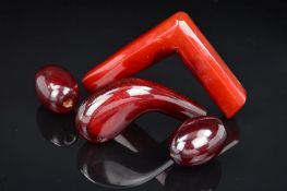 TWO RED PLASTIC WALKING STICK HANDLES AND TWO LARGE RED PLASTIC BEADS, one handle of curved shape,