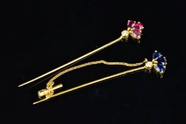 TWO 18CT GOLD GEM STICKPINS, both designed as a fan of three pear shape rubies or sapphires above