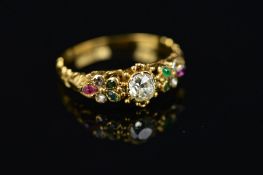 A 19TH CENTURY GOLD MULTI-GEMSTONE DRESS RING, centring on an old cut diamond, flanked by floral