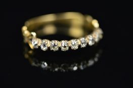 A LATE GEORGIAN GOLD DIAMOND RING, designed as nine old cut diamonds to the fancy tapered shoulders,