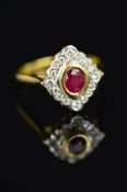 A MODERN 18CT GOLD RUBY AND DIAMOND CLUSTER RING, centring on an oval mixed cut ruby, measuring