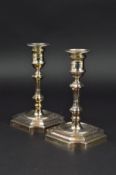 A PAIR OF GEORGE II STYLE CANDLESTICKS, detachable circular sconces, shaped square knopped