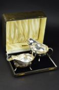 A CASED PAIR OF GEORGE VI SILVER SAUCEBOATS, wavy rim, 'C' scroll handle, on three cabriole legs,