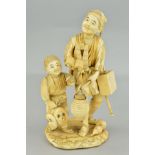 A LATE 19TH CENTURY JAPANESE SECTIONAL IVORY OKIMONO OF A MAN AND A BOY, the boy holding masks,