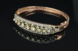 A DIAMOND SET OVAL HINGED BANGLE, rose cut diamonds set to one half graduating in size from 1.0mm to