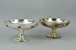 A PAIR OF SILVER PLATED ARTS & CRAFTS PEDESTAL BOWLS/TAZZAS, with eight red cabochons inset to the