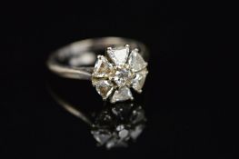 A MODERN ROUND CLUSTER DIAMOND RING, centring on an early round brilliant cut diamond within a