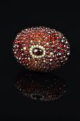 A VICTORIAN GARNET AND SEED PEARL BROOCH, an oval dome measuring approximately 35mm x 27mm,