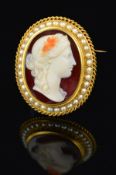 A 19TH CENTURY HARDSTONE CORNELIAN CAMEO BROOCH, depicting a woman in a classical manner, within a