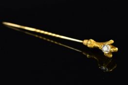 AN EARLY 20TH CENTURY GOLD AND DIAMOND STICKPIN, designed as an eagle talon holding an old cut