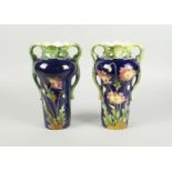A pair of Continental majolica Art Deco twin handled vases, with green glazed rims and handles,