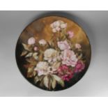 A large Victorian pottery charger, painted with roses, 59.5cm diameter