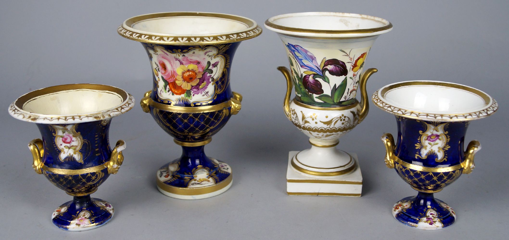 A pair of English porcelain campana shaped urns, 19th century, decorated with reserves of flowers