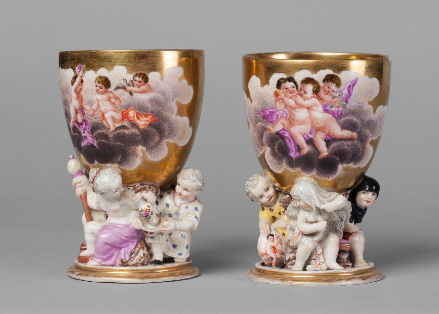 A pair of Berlin KPM goblets, 19th century, decorated with shaped vignettes of cherubs in clouds