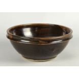 A Studio pottery bowl, 20th century, glazed in tenmoku glazes, with potters impressed seal mark to