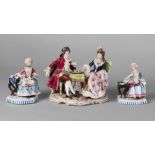 A pair of Continental porcelain figures of two ladies, 20th century, both seated at tables, one