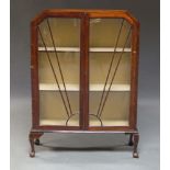 An Art Deco mahogany display cabinet, with sunburst moulded astragal glazed doors, enclosing two