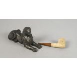 A spelter model of a Sphinx, late 19th/early 20th century, 17cm long, together with a clay pipe,