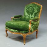 A French Louis XV style beech bergere armchair, 20th Century, the curved frame with scrolling