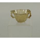 A Chinese pale agate cup, of hexagonal form with two handles carved with prunus blossom, 5cm high