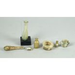 A collection of four Roman glass perfume flasks, one with a museum stand, 11cm long, together with a