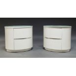 A Pair of contemporary oval bedside cabinets, with glass tops, and two drawers, 50cm high x 60cm