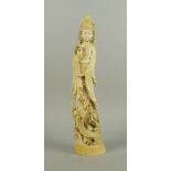 A Japanese carved ivory model of Guanyin, early 20th century, modelled standing holding a vase, on a