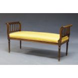 A Victorian mahogany window seat, upholstered in yellow fabric, the scrolling ends with carved
