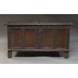 An oak blanket box, late 17th century, with four-panel front carved with floral motifs, on simple