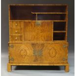 A figured walnut cabinet, early 20th Century, the top section with three drawers, a series of