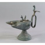 An Indian patinated bronze model of an oil lamp, late 19th/20th century, the loop handle with