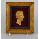 A wax profile portrait of Abraham Lincoln, 19th century, in a walnut veneer frame, the portrait