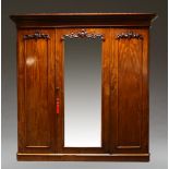 A Victorian mahogany triple wardrobe, the moulded cornice above three panelled doors, each with