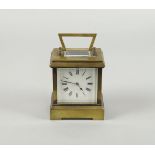 A Victorian brass carriage timepiece, the white enamel dial with Roman numeral chapter ring,