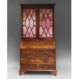 A George III bureau bookcase, the associated top with two astragal glazed doors, enclosing three