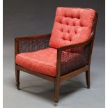 An Edwardian mahogany and caned library chair, the caned seat and backrest with red upholstered