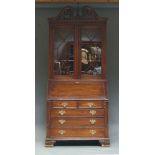 A George II style mahogany bureau bookcase, 20th Century, with carved and pierced swan neck pediment