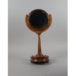 A Victorian walnut dressing table mirror, the plate of circular form, on a u shaped support, on