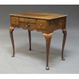 A George III oak three-drawer lowboy, on cabriole legs to pad feet, 81cm wide, 72cm high, 52cm deep