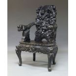 A Chinese hardwood armchair, 20th century, the back rest and arms pierced and carved with monkeys