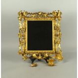 A Florentine gilt wood rectangular mirror, late 19th/early 20th century, decoratively carved with