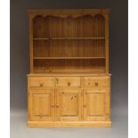 A large pine dresser, of recent manufacture, the moulded cornice above two shelves, with three