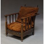 An Arts and Crafts oak chair in the manner of Gustav Stickley, with adjustable backrest and fold out