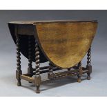 An oak gate leg dining table, early 20th Century, the oval top, with two drop leaves, on barley
